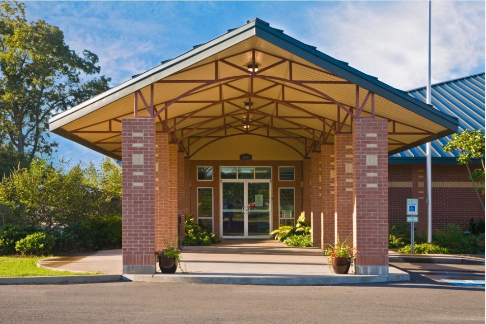Brick building entrance with yellow wood roof structure