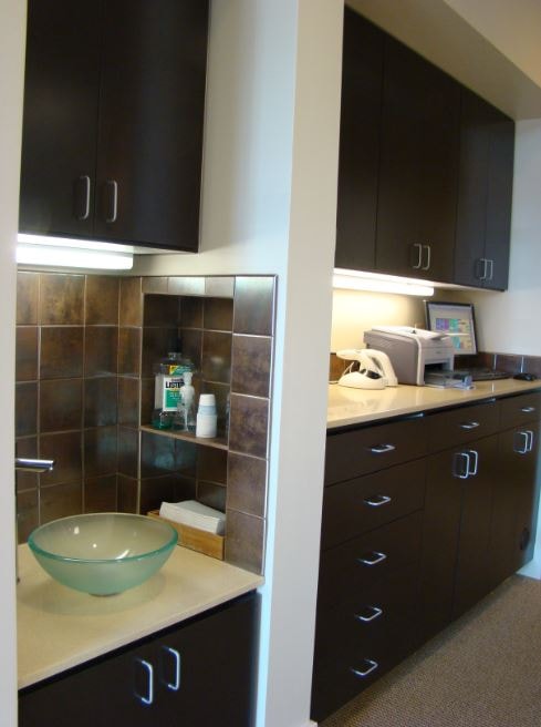 Dental operatory with dark cabinetry and vessel sink