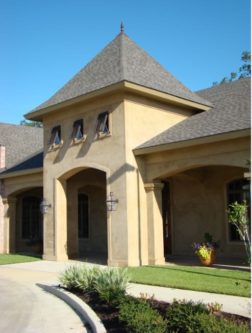 French stucco residential home with tower and arched portico