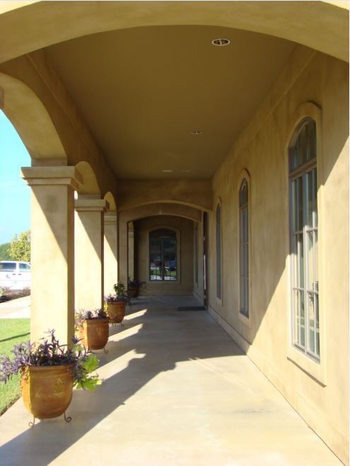 Stucco colonnade walkway with arched ceiling and potted plants