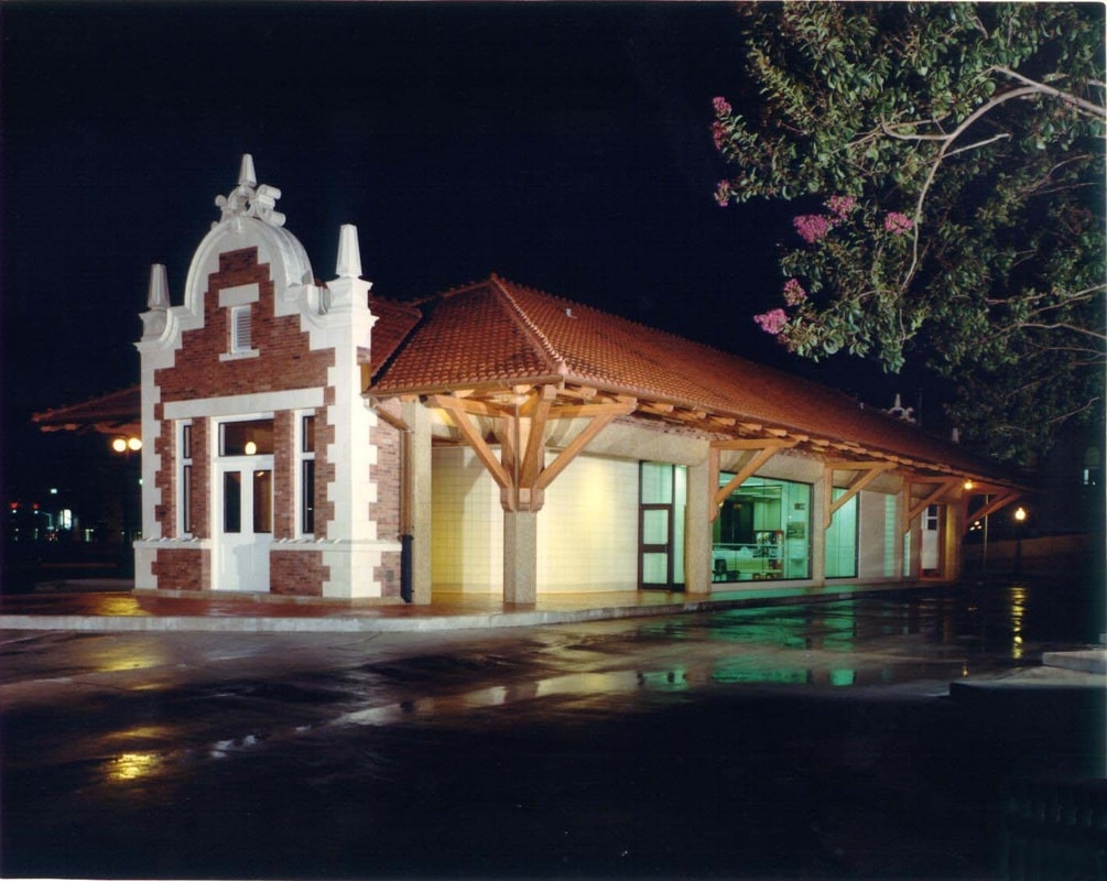 Restored historic transit building with brick facade and timber frame canopy at night